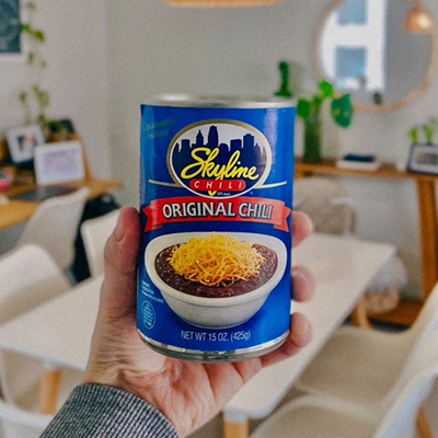 hand holding skyline chili can in their home