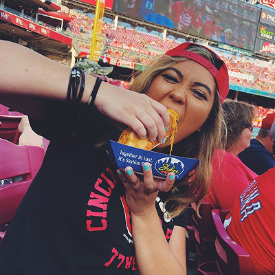 Woman at reds game eating a coney