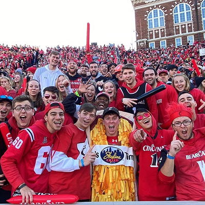 University of Cincinnati student fans, surrounding a guy dressed up as a skyline coney at a stadium